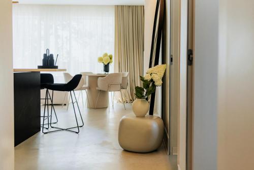 a living room with a table and a vase with flowers in it at By the lake apartment in Ostróda