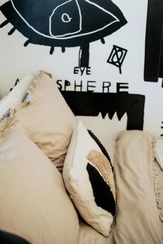a couch with pillows and a fish on the wall at By the lake apartment in Ostróda