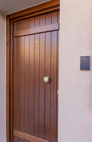a wooden door with a silver knob on a building at Meteora Living Rooms in Kastrákion