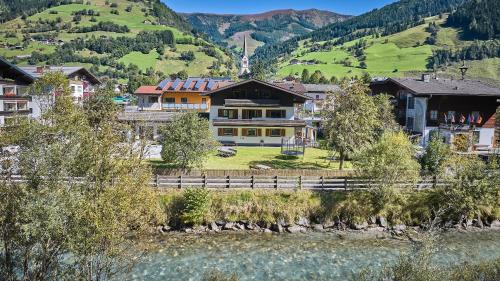 a large house with a fence in front of a mountain at Apartments Enzian in Rauris