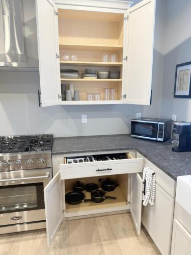 a kitchen with white cabinets and a stove at 2 Bd - Bourbon Lovers Dream - Clemson & Greenville in Easley