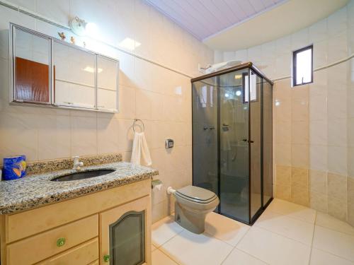 a bathroom with a toilet and a sink and a shower at Casa ampla perto da praia AG5245 in Gravata