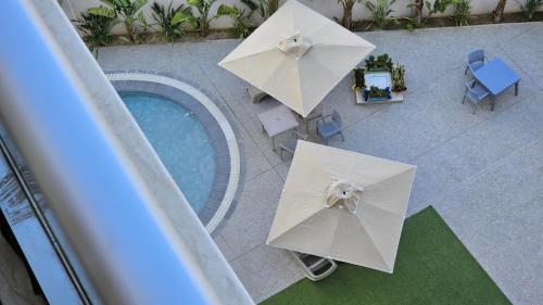 una vista aérea de dos sombrillas blancas junto a una piscina en Hammamet appart with pool, en Nabeul