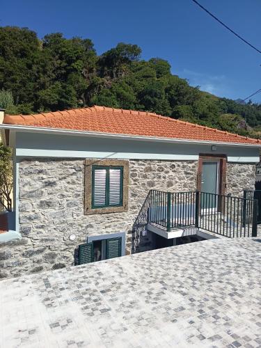 une maison en pierre avec un balcon et un bâtiment dans l'établissement Pousada Teixeira 11A, à São Vicente