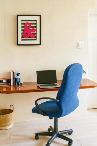 a blue chair in front of a desk with a laptop at Yellow Doors - Tranquil comfortable retreat in Saint James