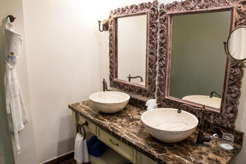a bathroom with two sinks and a large mirror at Sandos Finisterra All Inclusive in Cabo San Lucas