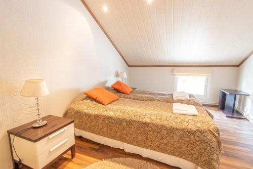 Un dormitorio con una cama y una mesa con una lámpara. en Pajuniemen Uusi Kartano, en Sotkamo