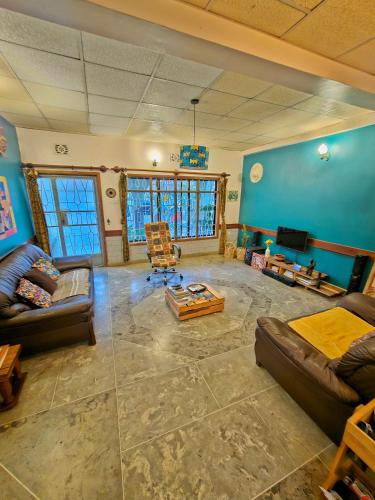 a large living room with blue walls and couches at Mazzola Safari House & Backpacking in Arusha