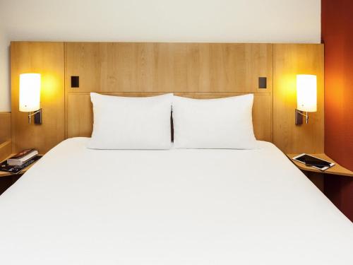 a large white bed in a hotel room at ibis Lyon Est Chaponnay in Chaponnay