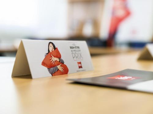 a book on a table with a picture of a woman at ibis Lyon Est Chaponnay in Chaponnay