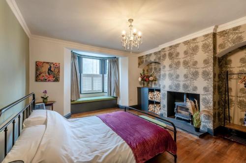 een slaapkamer met een bed en een open haard bij Bondgate House in Alnwick