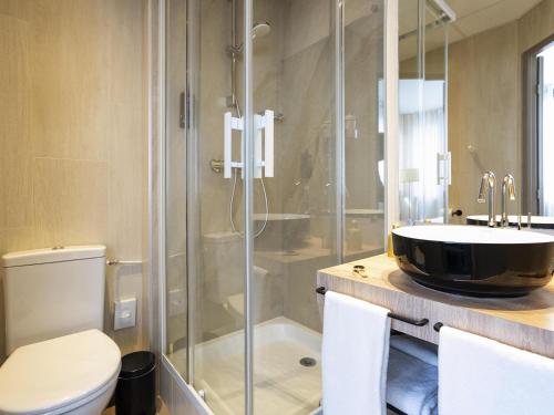 a bathroom with a shower and a toilet and a sink at ibis Styles Rennes St. Gregoire in Saint-Grégoire
