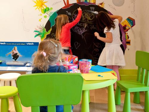 a group of children writing on a wall in a classroom at ibis Styles Rennes St. Gregoire in Saint-Grégoire