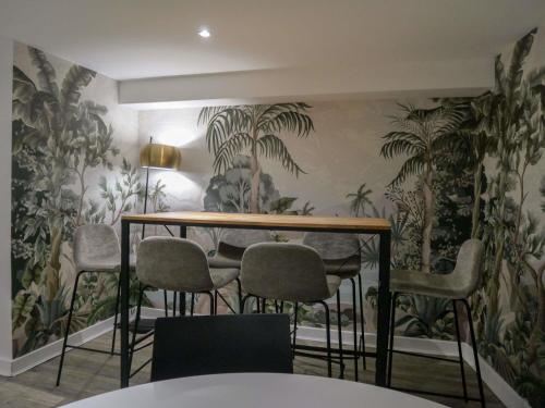 a table and chairs in a room with wallpaper at ibis Styles Saint Julien en Genevois Vitam in Neydens