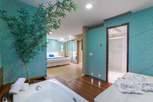 a bathroom with a bath tub and a bedroom at Wyndham Sao Paulo Ibirapuera Convention Plaza in Sao Paulo