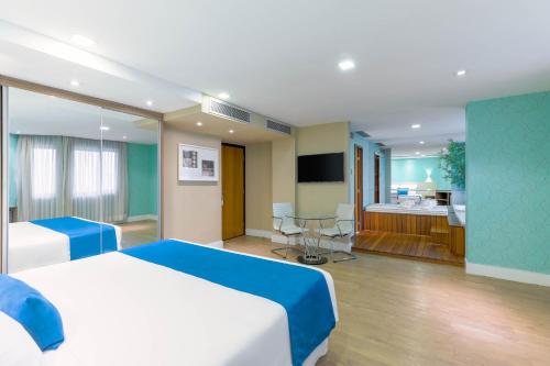 a hotel room with a bed and a bathroom at Wyndham Sao Paulo Ibirapuera Convention Plaza in Sao Paulo