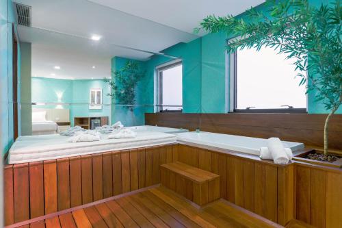 a large bathroom with a tub and a large window at Wyndham Sao Paulo Ibirapuera Convention Plaza in Sao Paulo