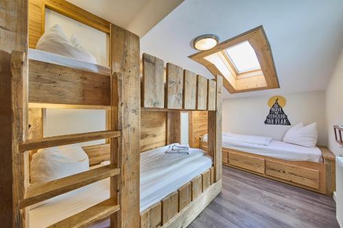 two bunk beds in a room with wooden walls at Apartments Enzian in Rauris