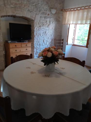 a white table with a vase of flowers on it at Appartment Plaza in Krnica