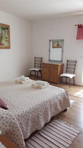 a bedroom with a bed and two chairs and a mirror at Appartment Plaza in Krnica