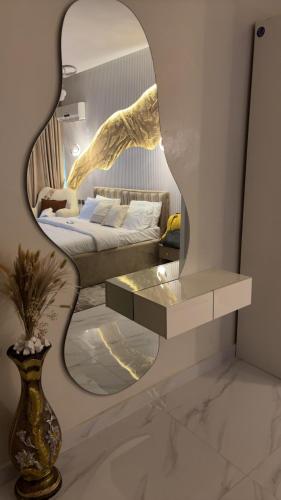 a mirror in a room with a bed and a table at The Ivory Luxe Suit Lekki phase 1 Lagos in Lagos