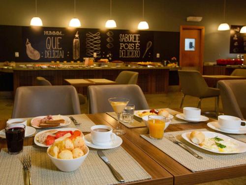 a wooden table with plates of food on it at ibis Vitoria Praia de Camburi in Vitória