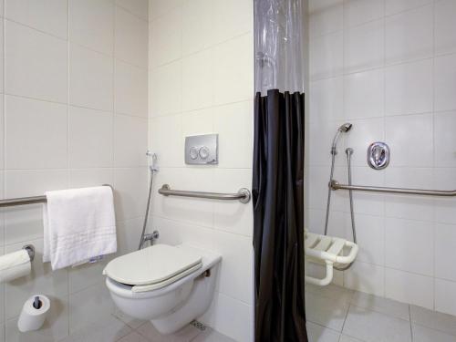 a bathroom with a toilet and a shower at ibis Vitoria Praia de Camburi in Vitória