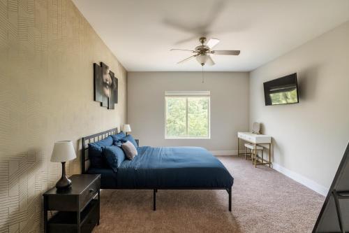 a bedroom with a blue bed and a ceiling fan at Spacious 2BR 2BA Condo Across from UAB in Homewood