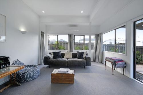 een woonkamer met een bank en een tafel bij Parnell Home with Pool, Parking and Rangitoto View in Auckland