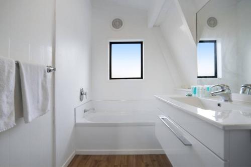 een witte badkamer met een bad en een wastafel bij Parnell Home with Pool, Parking and Rangitoto View in Auckland