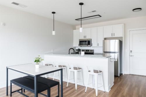 a kitchen with a white counter and a table and chairs at Luxury 2BR Condo Steps from UAB Campus 4th in Homewood