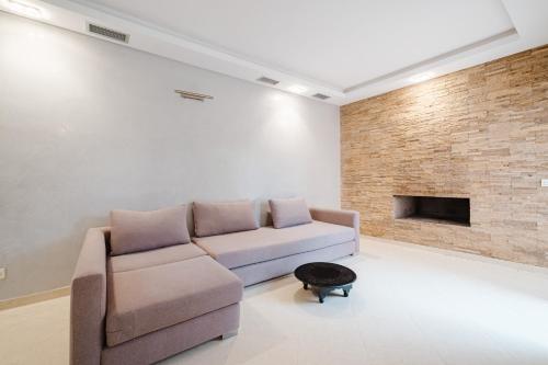 a living room with a couch and a brick wall at Villa with Private Garden & Pool Ourika, Atlas Mountains in Sidi Bouzguia
