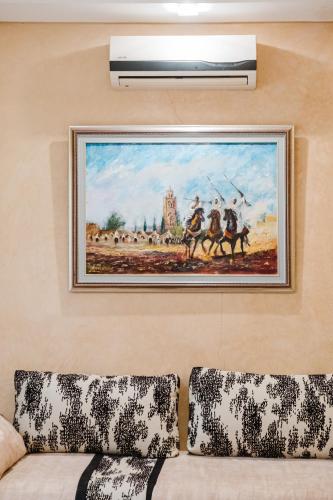 a painting hanging on a wall with a couch at Villa with Private Garden & Pool Ourika, Atlas Mountains in Sidi Bouzguia