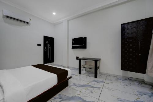 a white bedroom with a bed and a table at Hotel O Choice Inn II in Rao