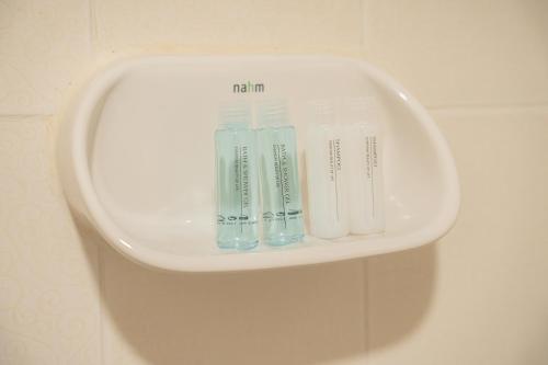 a white shelf with some toothbrushes in it at Ratchadamnoen Residence in Bangkok