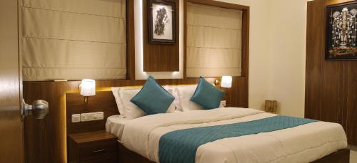 a bedroom with a large bed with blue pillows at Radha Madhavam Apartment's in Guruvāyūr