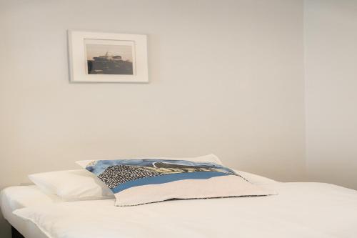 a white bed with a picture on the wall at Ratchadamnoen Residence in Bangkok