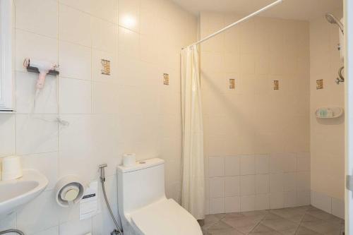 a bathroom with a shower and a toilet and a sink at Ratchadamnoen Residence in Bangkok