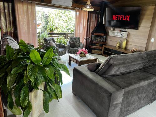 Una sala de estar con un sofá y una chimenea. en Casa ampla com área gourmet e piscina, en Capão da Canoa