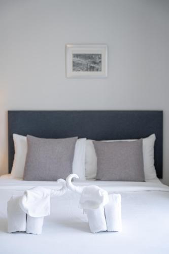a bedroom with a white bed with pillows at Ratchadamnoen Residence in Bangkok