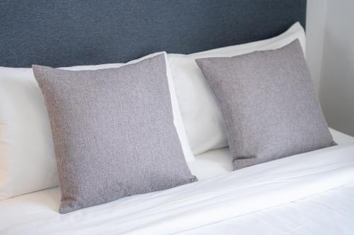 a bed with two gray pillows on it at Ratchadamnoen Residence in Bangkok