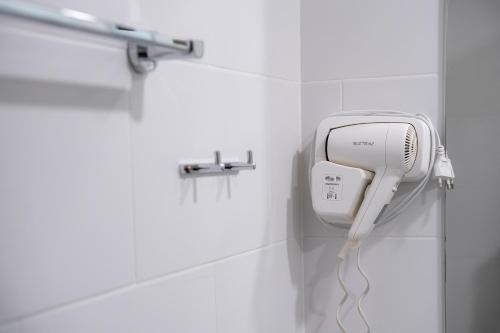 a hairdryer in a bathroom with a wall at Ratchadamnoen Residence in Bangkok