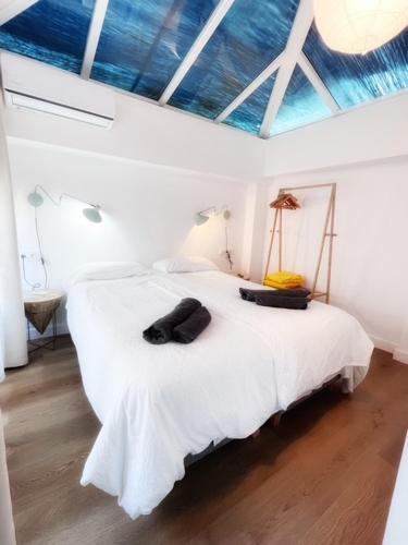a bedroom with a white bed with a blue ceiling at El Beaterio Apartments in Tarifa
