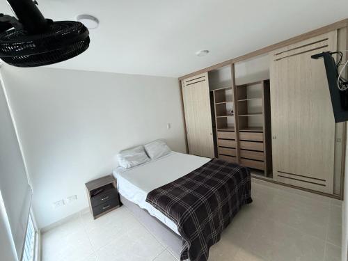 a small bedroom with a bed and a closet at Apartamentos en Club Residencial in Ibagué