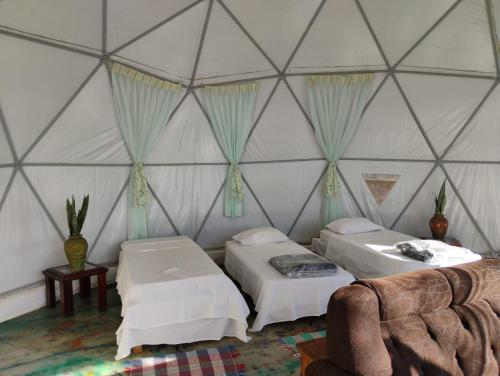 a room with two beds and a couch in a yurt at Pousada Spa Saúde Melhor in Extrema