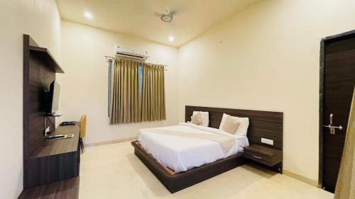 una camera da letto con un letto e una TV a schermo piatto di Redberry Resort Pushkar a Pushkar