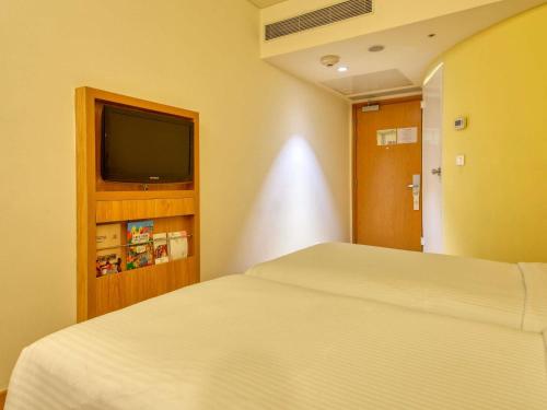 Un dormitorio con una cama y un televisor de pantalla plana. en ibis Bengaluru Outer Ring Road, en Bangalore