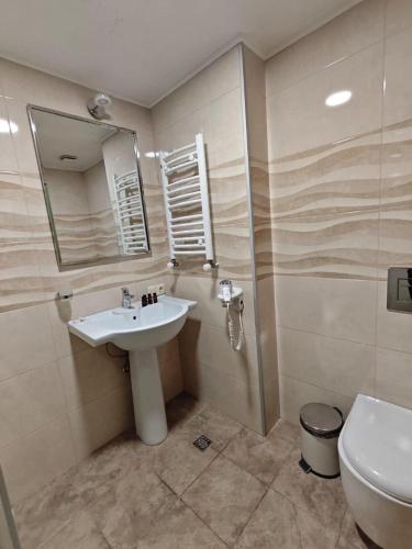 a bathroom with a sink and a toilet and a mirror at Orbi Palace Delux A in Bakuriani