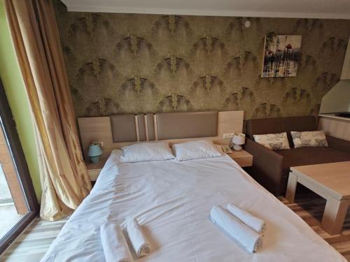 a bedroom with a bed with towels on it at Orbi Palace Delux A in Bakuriani