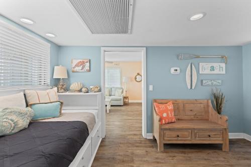 a bedroom with blue walls and a bed and a chair at Port O' Call B201 - Direct Oceanfront Views in Isle of Palms